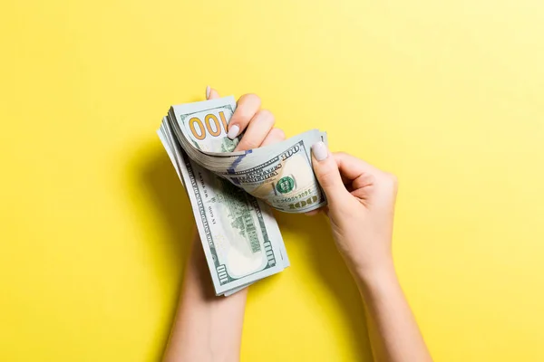 Nejlepší pohled na ženské ručičky počítání peněz. 100 dolarové bankovky na barevném pozadí. Obchodní koncepce — Stock fotografie