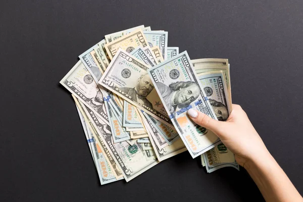 Renkli arka planda bir iş kadınının 100 dolarlık banknotları saymasının en üst görüntüsü. Başarı ve zenginlik kavramı