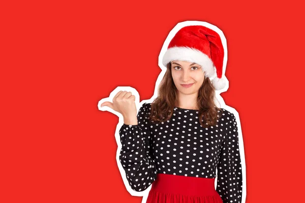 Porträtt av kvinna i klänning pekar vänster med tumme och upprörd. emotionell flicka i Santa claus jul hatt Magasin collage stil med trendig färg bakgrund. semesterkoncept — Stockfoto