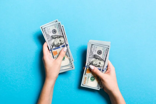 Pohled shora na ženskou ruku, jak dává nějaké peníze, detailní záběr na počítání stodolarových bankovek. Obchodní koncept na barevném pozadí — Stock fotografie
