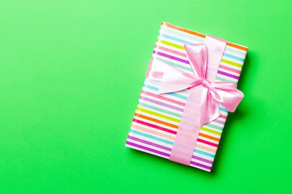 Top view Christmas present box with pink bow on green background with copy space — Stock Photo, Image