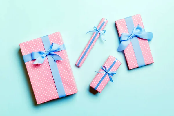 用蓝带蓝色背景的纸包裹着圣诞节或其他节日手工制作的礼物。礼物盒，彩色桌上的礼物装饰，顶视图 — 图库照片