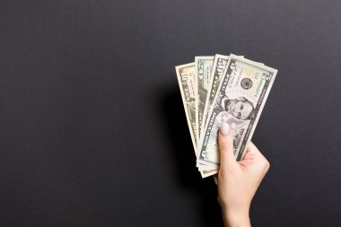 Femillerin elinde bir deste farklı banknot ve fotokopi alanı var. Renkli arkaplanda para tasarrufu kavramının üst görünümü