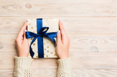 Sarı ahşap arka planda kadın eli var. Noel tatili ya da diğer tatiller için şenlikli bir zemin. Fotokopi alanı ile düz serili biçim üst görünümü