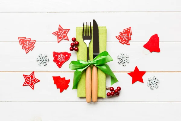 Top view of New Year dinner on wooden background. Festive cutlery on napkin with christmas decorations and toys. Close up of family holiday concept — Stock Photo, Image