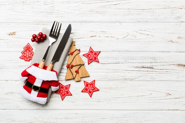 Draufsicht auf Gabel und Messer mit Band auf Serviette auf Holzgrund. Weihnachtsschmuck und Neujahrsbaum. Glückliches Urlaubskonzept mit Leerraum für Ihre Gestaltung — Stockfoto