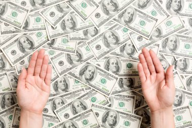 Dolar arka planda kadın elleri üst görünümü. Tasarım için boş alan ile zenginlik kavramı. Dilencilik para kavramı