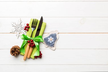 Yeni yıl yemeğinin en iyi manzarası ahşap arka planda. Noel süslemeleri ve oyuncaklarıyla peçetenin üzerindeki şenlikli çatal bıçak takımı. Fotokopi alanı olan aile tatili kavramı