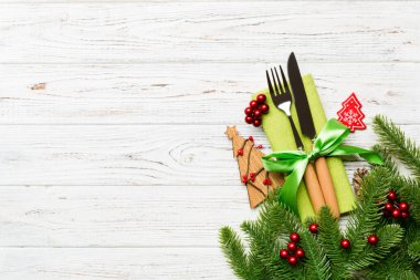 Peçetedeki çatal ve bıçak manzarası, Noel süslemeleri ve tahta zemin üzerinde yeni yıl ağacı. Kopya alanı ile bayram ve festival konsepti