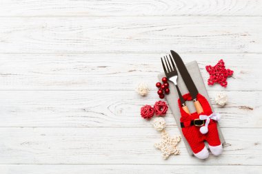 Tahta arka planda çatal ve bıçak seti. Noel süslemeleri ve fotokopi alanı olan oyuncaklar. Yeni yıl arifesi kavramı