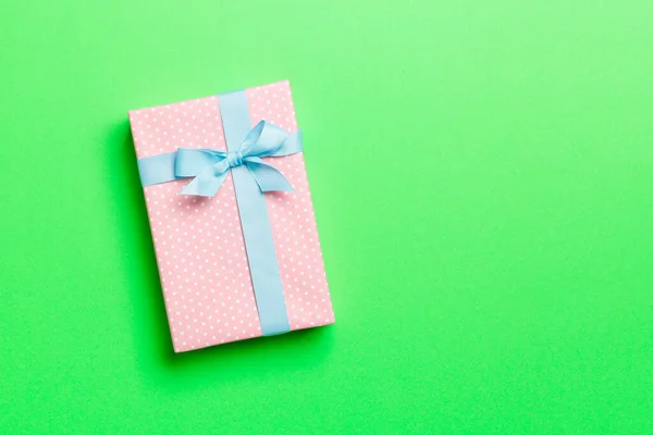 包装圣诞节或其他节日手工纸制礼物，蓝带绿色背景。礼品盒，彩色桌上的礼品装饰，顶部有复印空间 — 图库照片