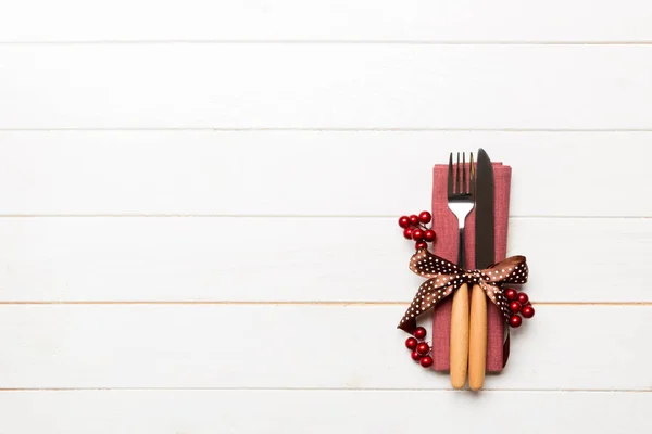 Vista superior de la cena de Año Nuevo sobre fondo de madera. Cubertería festiva en servilleta con decoraciones navideñas y juguetes. Concepto de vacaciones en familia con espacio de copia — Foto de Stock