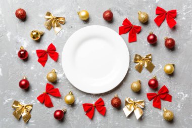 Çimento arka planındaki bayram yemeğinin en üst görüntüsü. Tabak, takılar ve fiyonklar. Noel Arifesi konsepti