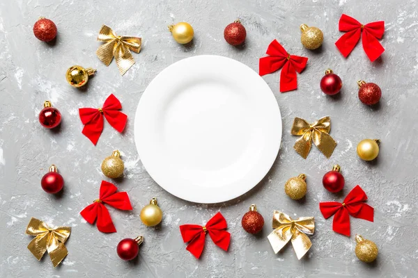 Top view of holiday dinner on cement background. Plate, baubles and bows. Christmas Eve concept — Stock Photo, Image