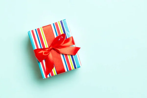 Caixa de presente com arco vermelho para o dia de Natal ou Ano Novo no fundo azul, vista superior com espaço de cópia — Fotografia de Stock