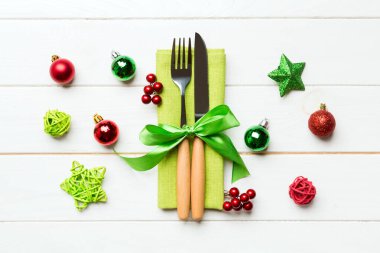 Tahta arka planda çatal ve bıçak seti. Noel süslerini ve oyuncaklarını kapatın. Yeni yıl arifesi kavramı