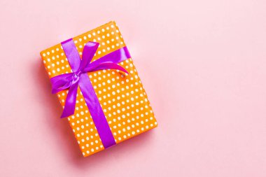 Noel için mor fiyonklu hediye kutusu ya da pembe arka planda yeni yıl günü, fotokopi alanı olan üst görünüm