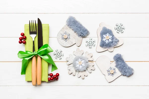 Top view of New Year dinner on wooden background. Festive cutlery on napkin with christmas decorations and toys. Close up of family holiday concept — Stock Photo, Image