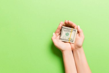 Renkli bir geçmişi olan kadınların elindeki dolar banknotlarının en üst görüntüsü. Emeklilik ve yoksulluk kavramı