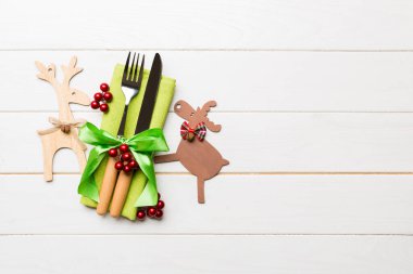 Noel süslemeleri ve ahşap arka planda ren geyiği olan peçetedeki yeni yıl aletlerinin en üst görüntüsü. Fotokopi alanı ile Noel yemeği konsepti