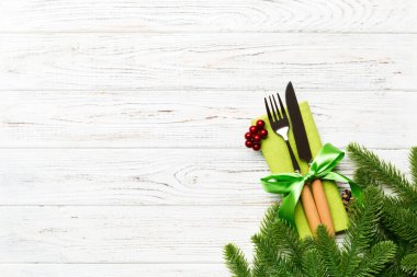 Ahşap arka planda noel süslerinin en üst görüntüsü. Peçetedeki çatal ve bıçak kurdeleyle bağlanmış ve senin tasarımın için boş bir alan. Yeni yıl şablonu kavramı