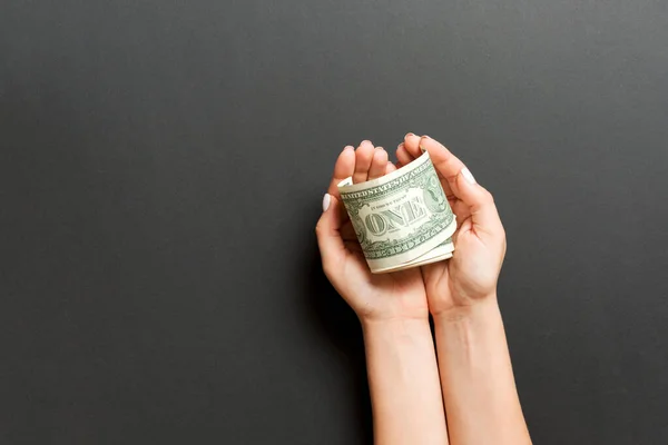 Horní pohled na dolarové bankovky v ženských rukou na barevném pozadí. Koncept odchodu do důchodu a chudoby — Stock fotografie