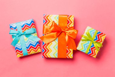 Noel için mavi, yeşil ve turuncu fiyonklu hediye kutusu ya da yaşayan mercan arka planında yeni yıl günü, üst görünüm