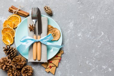 Çimento arka planında kurutulmuş meyve ve tarçınla süslenmiş bayram yemeği manzarası. Tabak takımı, urensil ve yeni yıl süslemeleri. Tasarımınız için epmty alanı olan Noel zamanı konsepti