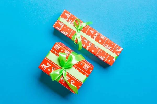 用绿色带蓝色背景的纸包裹圣诞节或其他节日手工制作的礼物。 礼物盒，彩色桌上的礼物装饰，顶视图 — 图库照片
