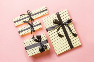 Pembe arka planda siyah kurdeleli Noel hediyesi kutusu