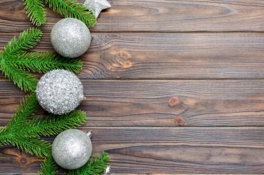 Şenlik baloları, köknar ağacı ve ahşap arka planda Noel süslemeleri. Kopya alanı ile yeni yıl süsü konseptinin en üstü görünümü