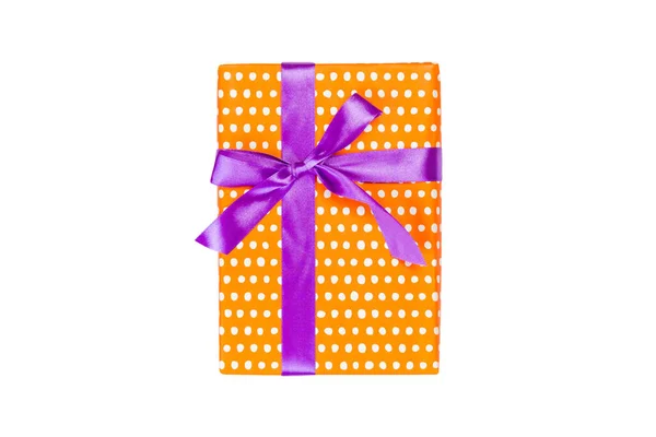Karácsonyi vagy más ünnep kézzel készített ajándék narancssárga papír lila szalaggal. Elszigetelve, fehér háttérrel, felülnézetben. Hálaadás ajándék doboz koncepció — Stock Fotó