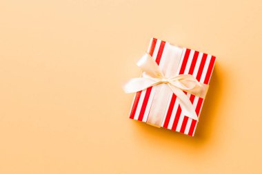 Üst manzara Noel hediyesi kutusu, turuncu arka planda sarı fiyonk ve kopya alanı var.