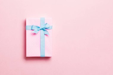 Noel 'de mavi fiyonklu hediye kutusu ya da pembe arka planda yeni yıl günü, fotokopi alanı olan üst görünüm