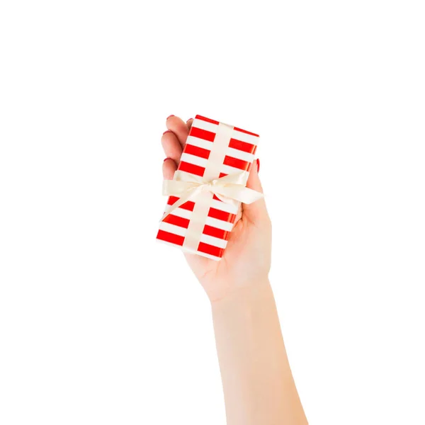Kvinnliga händer ger insvept jul eller annan semester handgjorda present i rött papper med guldband. Isolerad på vit bakgrund, ovanifrån. Thanksgiving Gift box koncept — Stockfoto