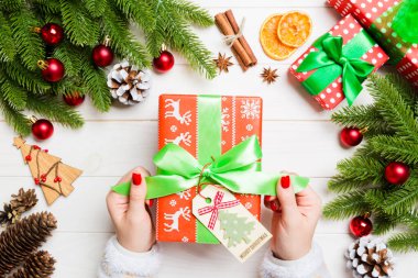 Kadın eli görüntüsü, yeni yılı şenlikli ahşap arka planda kutluyor. Firavun ağacı ve tatil süslemeleri. Noel zamanı konsepti