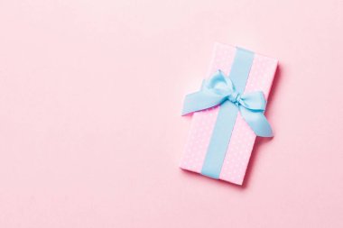 Üst görünüm Noel hediyesi kutusu üzerinde mavi fiyonk ve fotokopi alanı ile pembe arkaplan