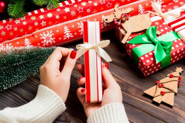 Kadın eli görüntüsü, yeni yılı şenlikli ahşap arka planda kutluyor. Firavun ağacı ve tatil süslemeleri. Noel zamanı konsepti