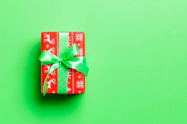 Top view Χριστουγεννιάτικο κουτί δώρου με πράσινο τόξο σε πράσινο φόντο με αντίγραφο χώρου — Φωτογραφία Αρχείου