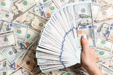 Kadın ellerinin farklı dolar arkaplanındaki paraları sayması. Borç konsepti. Yatırım kavramı.