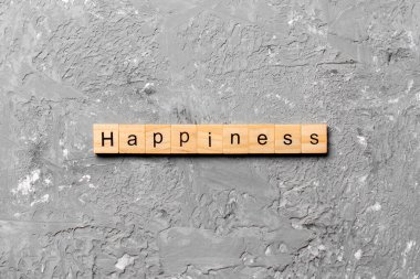 Tahta blokta yazan mutluluk kelimesi. Masada mutluluk metni, konsept.