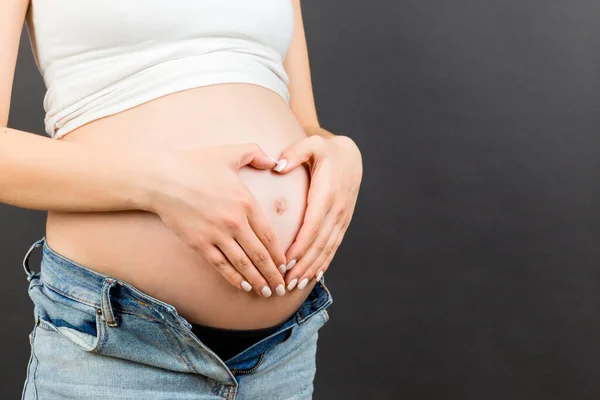 Primer Plano Mujer Embarazada Jeans Desabrochados Sosteniendo Sus Manos Forma —  Fotos de Stock