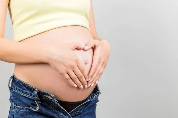 Primer Plano Mujer Embarazada Jeans Desabrochados Sosteniendo Sus Manos Forma —  Fotos de Stock