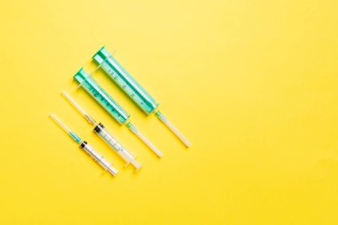 Renkli arkaplanda fotokopi alanı olan tıbbi enjeksiyon için üst sıradaki şırıngaların görüntüsü. Sağlık ve aşı kavramı.