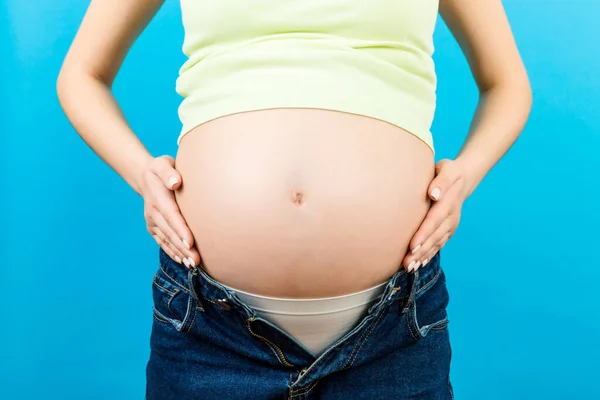Close Mulher Grávida Jeans Abertos Acariciando Seu Bebê Colisão Fundo — Fotografia de Stock