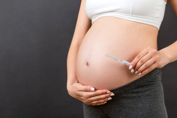 Close Mulher Grávida Segurando Uma Seringa Contra Sua Barriga Fundo — Fotografia de Stock