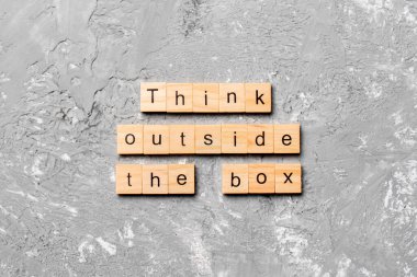 Tahta blokta yazan kutunun dışını düşün. Top view konseptin için çimento masasının üzerindeki kutu metnin dışında düşün..