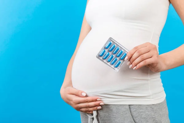 Imagen Recortada Mujer Embarazada Sosteniendo Una Ampolla Píldoras Contra Vientre —  Fotos de Stock
