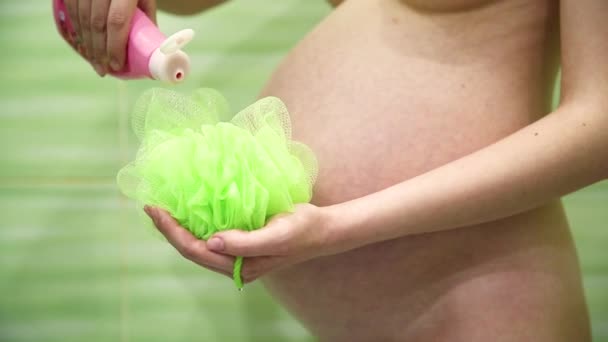 Schwangere Unter Der Dusche Schäumt Ein Grünes Waschlappen Unter Wasser — Stockvideo