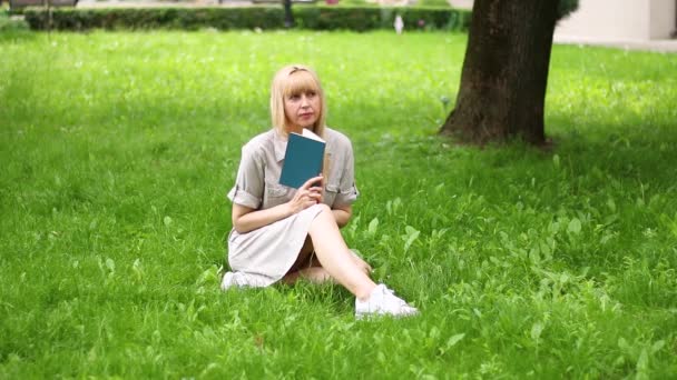 Mulher Senta Parque Grama Dia Ensolarado Pensa Sobre Livro Leitura — Vídeo de Stock